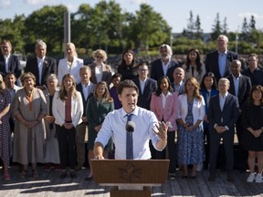 Prime Minister Justin Trudeau speaks to reporters as cabinet members look on during the Liberal retreat in Charlottetown, P.E.I. on Wednesday, August 23, 2023.