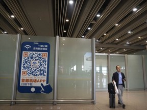FILE - A traveler walks through the international flight arrivals area at Beijing Capital International Airport in Beijing, on April 26, 2023. China will no longer require a negative COVID-19 test result from incoming travelers starting Wednesday, Aug. 30, 2023.