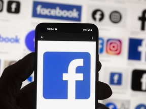 The Friends of Canadian Broadcasting group is asking people to stop posting content on Meta's platforms on Aug. 23 and 24. The Facebook logo is seen on a mobile phone, Oct. 14, 2022, in Boston.