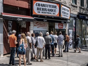 The lunch hour crowd line up outside Schwartz’s Deli on Saint-Laurent Blvd. in Montreal on Thursday May 11, 2023.