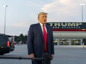 Former President Donald Trump speaks with reporters before departure from Hartsfield-Jackson Atlanta International Airport, Thursday, Aug. 24, 2023, in Atlanta.