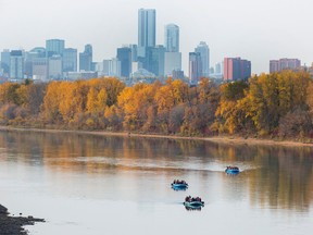 Rafters make their way down the North Saskatchewan River against a backdrop of the Downtown skylline