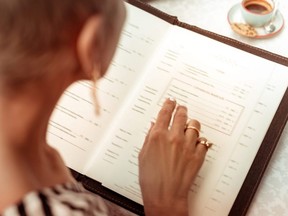 A woman reads the menu in a restaurant.
