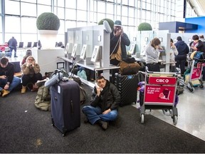 Passenger dealing with delays and cancellations wait in line for phone to contact the airlines at Terminal 1 departures level at Toronto Pearson International Airport on Friday December 23, 2022.