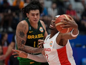 Canada's Shai Gilgeous-Alexander and Brazil's Gui Santos fight for the ball during the FIBA Basketball World Cup group L match.