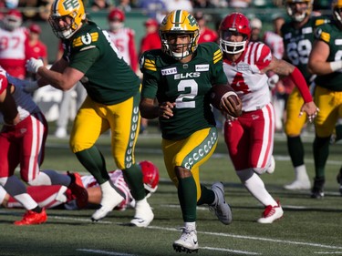 Elks quarterback Tre Ford runs with the ball, with a Calgary Stampeder defender chasing him