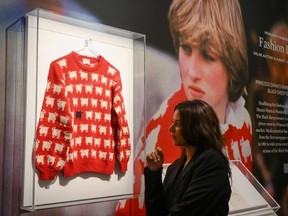 A staff member poses with the "Black Sheep Jumper" designed by Sally Muir and Joanna Osborne and worn on several occasions by Britain's late Princess Diana, during a press view at Sotheby's auction house in London on July 17, 2023.