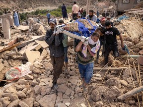 People carry the remains of a victim of the deadly 6.8-magnitude Sept. 8 earthquake, in the village of Imi N'Tala near Amizmiz in central Morocco on Sept. 10, 2023.