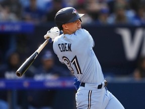 Cam Eden of the Toronto Blue Jays hits a single for his first Major League hit against the Tampa Bay Rays during the second inning in their MLB game at the Rogers Centre on October 1, 2023 in Toronto, Ontario, Canada.