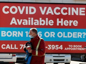 A pedestrian walks past a sign advertising COVID-19 vaccines at the Shoppers Drug Mart, 8065 104 St., in Edmonton Wednesday April 21, 2021.