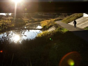 A cyclist crosses under 30 Avenue SW while making their way along the Cavanagh walking trails, in Edmonton Thursday Oct. 19, 2023.