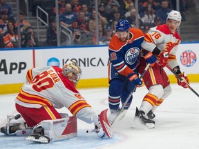 Oilers forward Connor Brown battles Flames goalie Dan Vladar for the puck