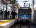 Passengers board an LRT car on an outdoor platform