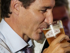 Justin Trudeau drinks a pint of beer as he makes a whistle-stop at the Hawthorne Beer Market in Surrey, B.C., on Aug 18, 2021.