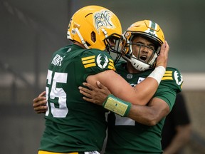 Edmonton Elks quarterback Tre Ford (right) and Mark Korte (65) hug as they celebrate a touchdown