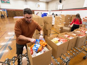 A man packs a box of food on an assembly line in a school gymnasium