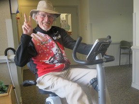Yardley Jones seated on an exercise bike flashing the peace sign