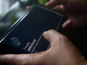 A person holds a smartphone set to the opening screen of the ArriveCan app in a photo illustration made in Toronto on June 29, 2022. PHOTO BY GIORDANO CIAMPINI /The Canadian Press