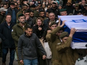 HAIFA, ISRAEL - JANUARY 23: Family and friends mourn as they walk behind the coffin during the funeral of Sergeant major (res) Matan Lazar, killed in a battle in south Gaza on January 23, 2024 in Haifa, Israel. On January 22, 24 Israeli soldiers were killed fighting against Hamas, including 21 reservists in a single attack. Benjamin Netanyahu announced the opening of an investigation, referring to "one of the hardest days" for the Israeli army since the start of the war on October 7th. (Photo by Amir Levy/Getty Images)