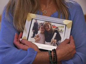 Lisa Loumakos holds an old photo of her mom Stella Skarmoutsos with her daughter Zoey, now 15, on Thursday, Jan. 25, 2024. Stella, 77, died of lung cancer in her daughter's Mississauga home on Sept. 22, 2023, before she was able to secure her permanent resident status so Lisa is now on the hook for $60,000 in medical bills.