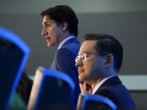 Prime Minister Justin Trudeau, left, and Conservative Leader Pierre Poilievre take part in the National Prayer Breakfast in Ottawa, May 30, 2023.