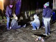 A member of the fathers' group kneels next to a break-and-enter suspect in Fort Langley.