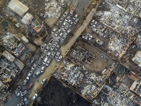 Burnt cars lie on a street after a forest fire reached Villa Independencia neighborhood in Vina del Mar, Chile, Saturday, Feb. 3, 2024.