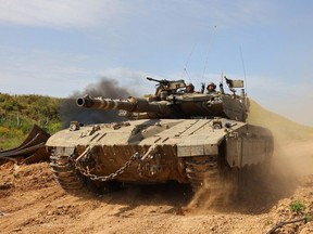 This picture taken from Israel's southern border with the Gaza Strip shows an Israeli tank moving along the border with the Palestinian territory on March 21, 2024, amid the ongoing conflict between Israel and the militant group Hamas.