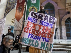 A man holds up an anti-Israel banner during a demonstration at Palestine Square in Tehran on Sunday, March 24, 2024, amid the ongoing conflict in the Gaza Strip between Israel and the Palestinian militant group Hamas.