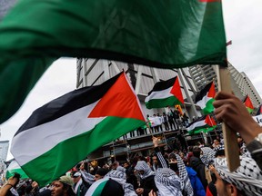 Demonstrators in support of Palestinians wave Palestinian flags during a protest in Toronto on Oct. 9, 2023.