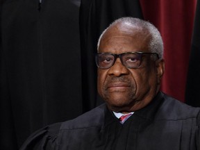 In this file photo taken on October 7, 2022 associate US Supreme Court Justice Clarence Thomas poses for the official photo at the Supreme Court in Washington, DC.