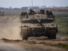 Israeli soldiers drive a tank on the border with Gaza Strip, in southern Israel, Tuesday, March 19, 2024.
