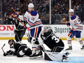 Viktor Arvidsson (33) and Cam Talbot (39) of the Los Angeles Kings defend against Zach Hyman (18) of the Edmonton Oilers as he attempts to tip a shot on goal during Game 3 of the first round of the 2024 Stanley Cup Playoffs at Crypto.com Arena on April 26, 2024, in Los Angeles, Calif.