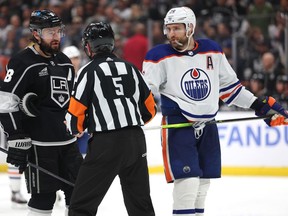 Referee Chris Rooney (5) addresses Leon Draisaitl (29) of the Edmonton Oilers and Drew Doughty (8) of the Los Angeles Kings during Game 3 of the first round of the 2024 Stanley Cup Playoffs at Crypto.com Arena on April 26, 2024, in Los Angeles, Calif.