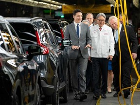 Prime Minister Justin Trudeau (left), alongside the Head of Honda Global, Toshihiro Mibe (centre) and Ontario Premier Doug Ford (right) tours the manufacturing line prior to an event at the Honda of Canada Manufacturing Plant 2 in Alliston, Ont., on April 25, 2024.