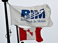 The flag of Research in Motion Ltd., maker of the Blackberry wireless device, and the the Canadian flag fly outside the company's headquarters in Waterloo, Ontario. RIM reports quarterly earnings after markets close on Thursday