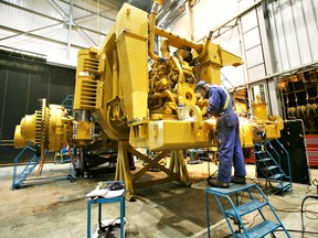A Finning Canada employee works on the bumper of a Caterpillar 797 dump truck during its assembly on the grounds of The Syncrude Project in Fort McMurray, Alberta