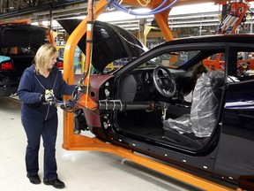 A Chrysler Group LLC employee works on the assembly line during the production launch of Chrysler vehicles at the assembly plant in Brampton.