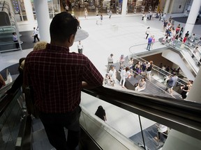 A shopper rides the escalator at Eaton Centre in Toronto, Ontario.