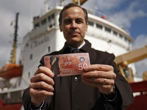 Bank of Canada Governor Mark Carney holds a new 50 dollar bill in Quebec City on March 26, 2012. For the loonie, the near-term reaction will likely be slightly negative, primarily due to the uncertainty regarding his replacement, analysts said after Mr. Carney announced he was leaving the Bank of Canada to take the top job at the Bank of England.