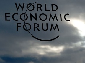 The logo of the World Economic Forum against a backdrop of cloudy skies. A study of global CEOs released on the first day of the forum shows optimism over revenue growth to be waning globally but improving in Canada.