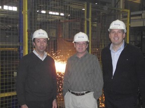 Burnco executives Homer Sayyad, president, left, John Boote, manager of structural steel, and Erwin Terwoord, director of business development, stand near a robot modified and programmed to cut geometric shapes in steel beams.