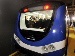 Train operator Allison Pringle(L), Federal Minister Stockwell Day(2L), B.C. Premier Gordon Campbell(C), Transport Minister Kevin Falcon(2R) and Jim Burke(R) of SNC-Lavalin ride a Canada Line Train on its first return run from Waterfront Station to the end of the airport line at YVR Friday, March 27, 2009 in Vancouver.