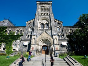People pass University College at the University of Toronto.