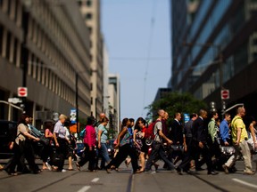 Pedestrians walk on Bay Street in the financial district of Toronto. Canada's record 74,000-job crash in the public sector in July may have brought with it some new clarity — and urgency — to the country’s post-recession reality.