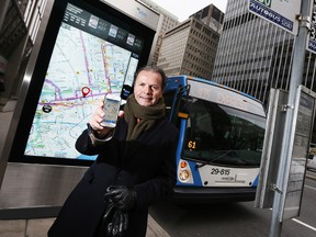 Pierre Bourbonniere, Director of marketing at Societe de transport de Montreal (STM) poses with his Merci app in front of their new interactive digital transit shelter on the streets of downtown Montreal, November 14, 2013.