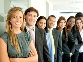 group of business people smiling in an office lined up