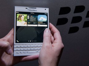 An attendee demonstrates a BlackBerry Passport smartphone during a product announcement in Toronto. The Passport runs BlackBerry's BB10.