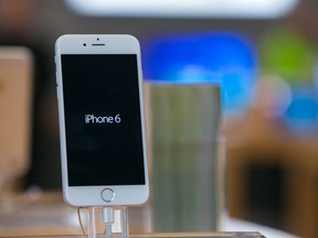 An iPhone 6 smartphone stands on display in an Apple Store.
