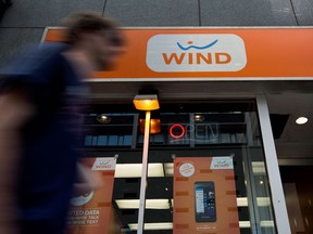 A pedestrian walks in front of a Wind Mobile SA store in Toronto.